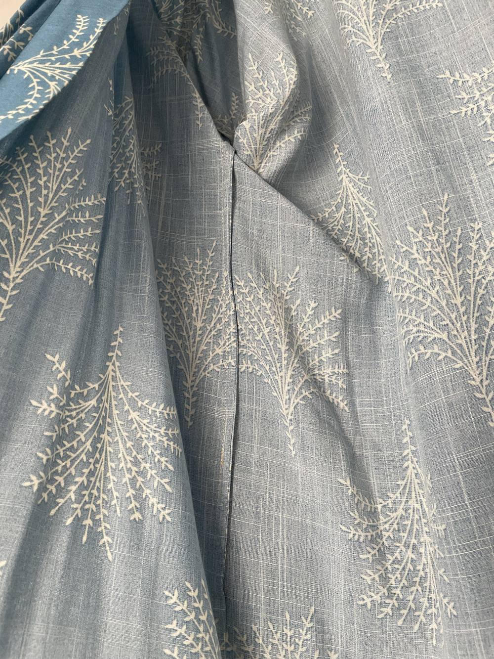 Le tissu imprimé de feuillages écrus sur fond bleu